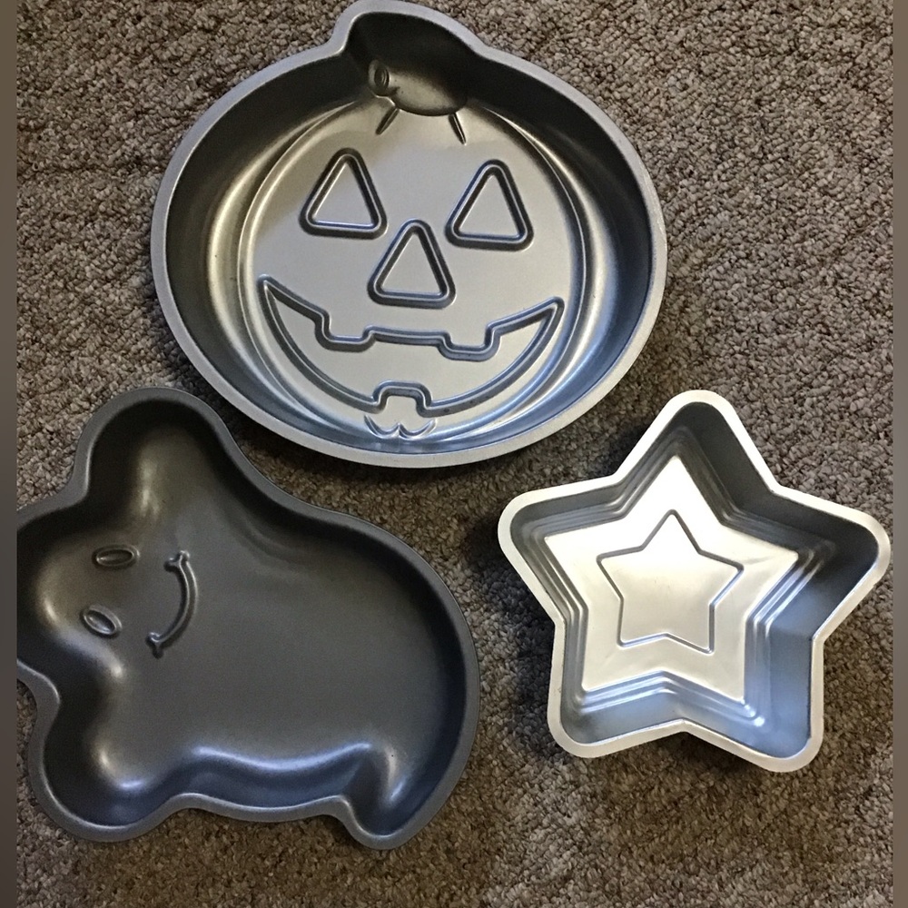 A total of 3 cake pans one star, one ghost , one pumpkin